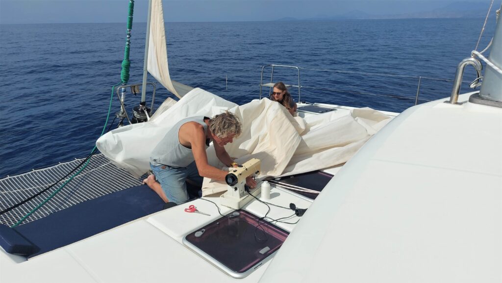 Segelreparatur auf hoher See. Gut, wenn man eine Nähmaschine zur Hand hat.