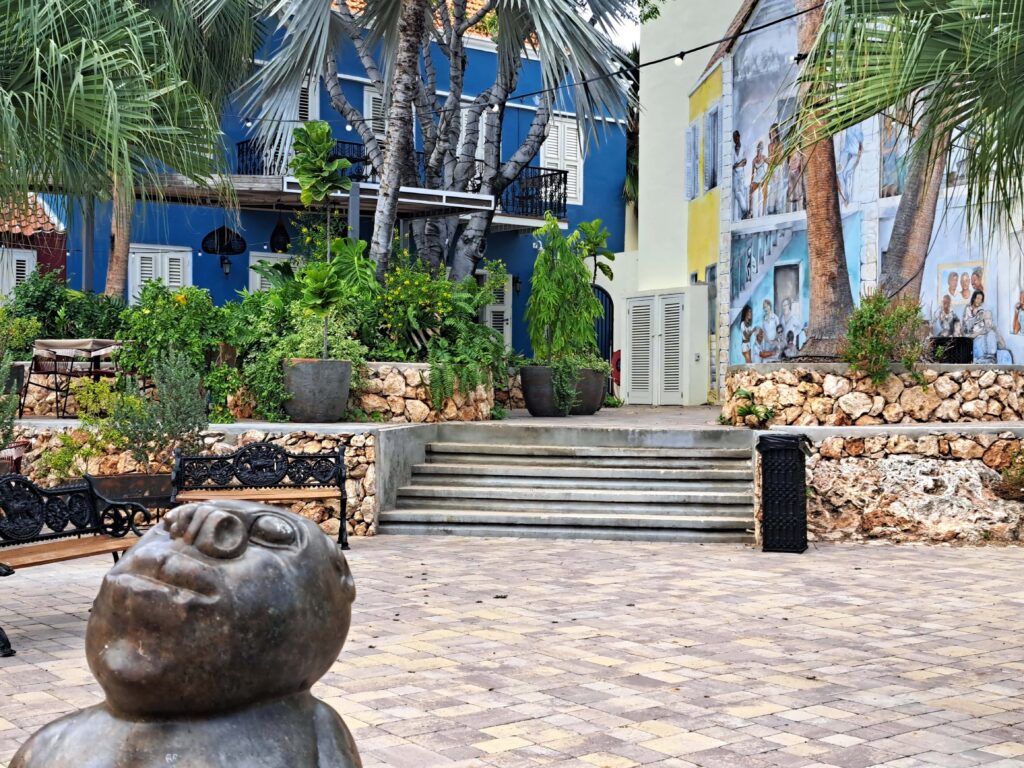 Skulptur vor blauem Haus