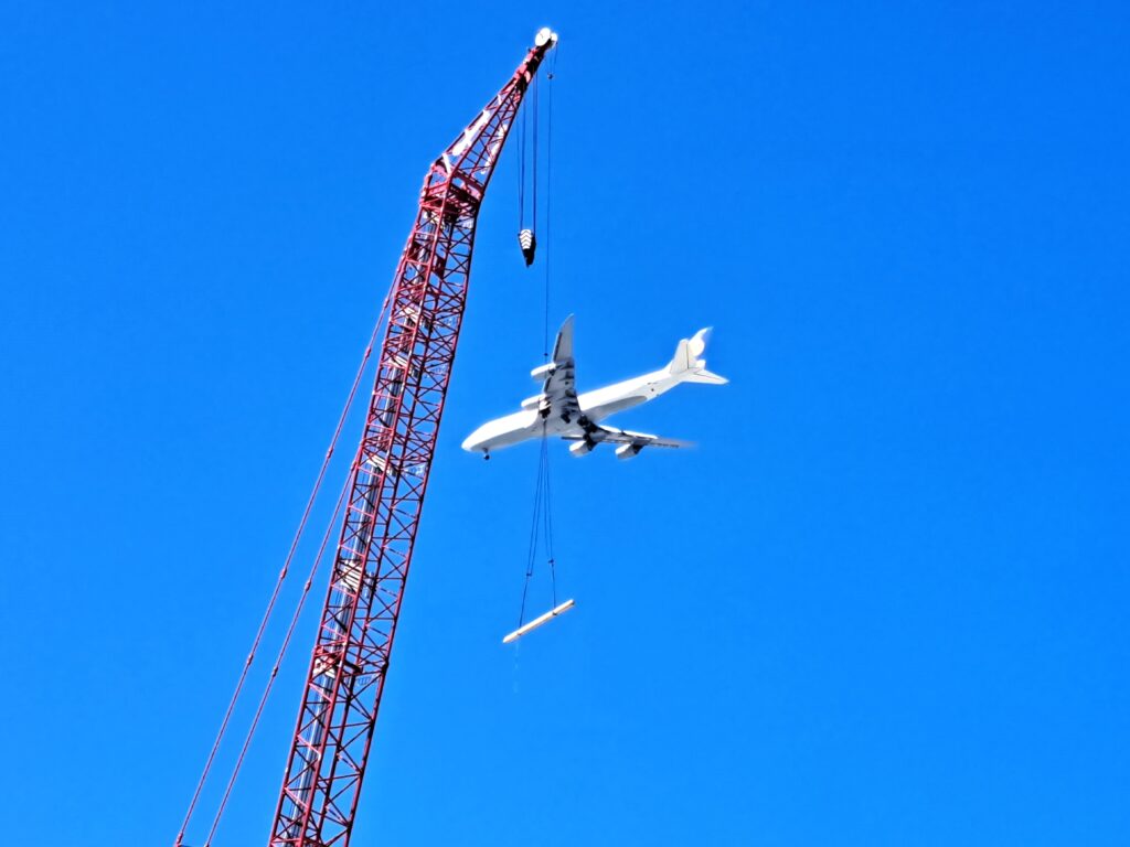 Flugzeug fliegt an Kran vorbei